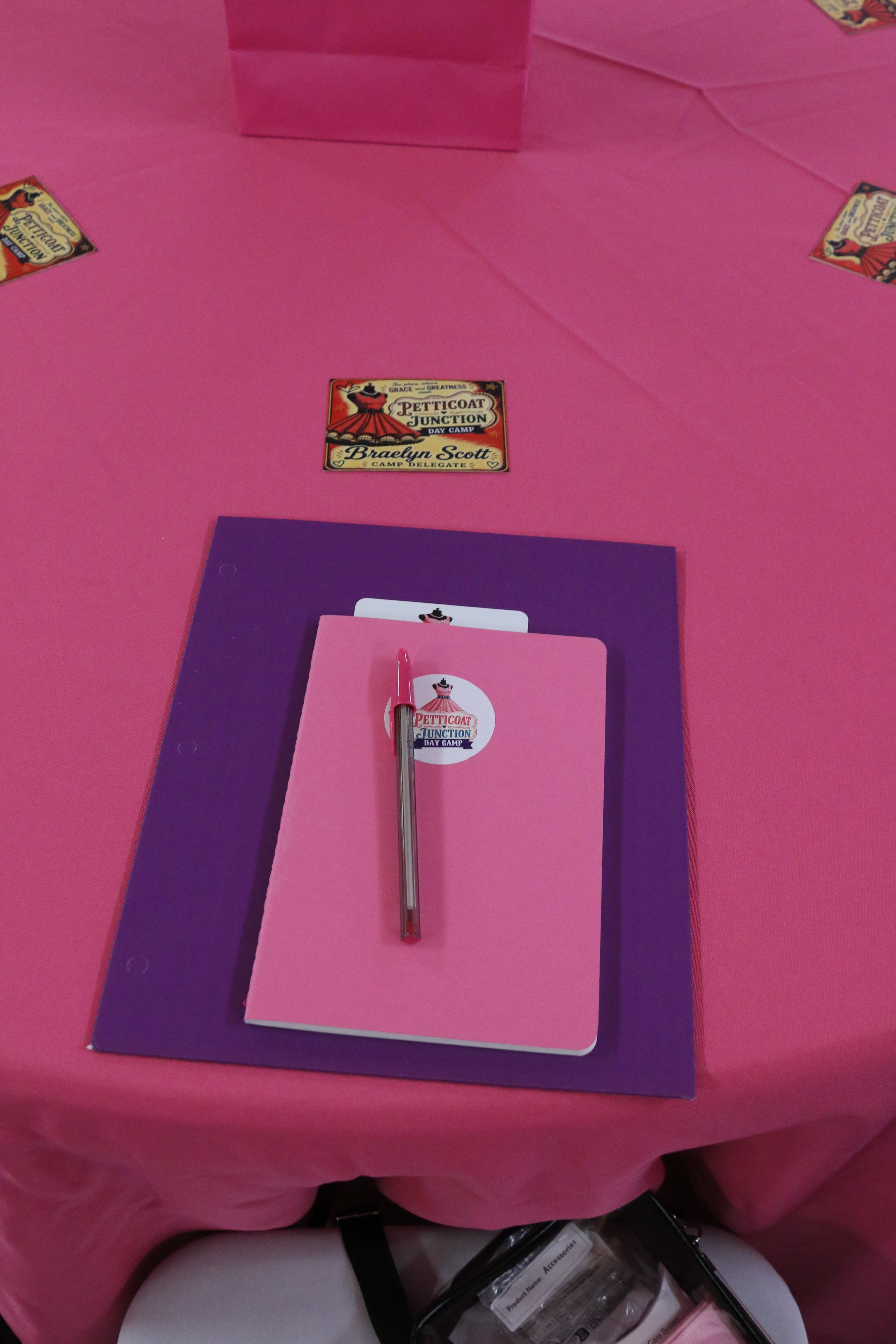 Petticoat Junction Day Camp pink and purple table setup with branded stationery